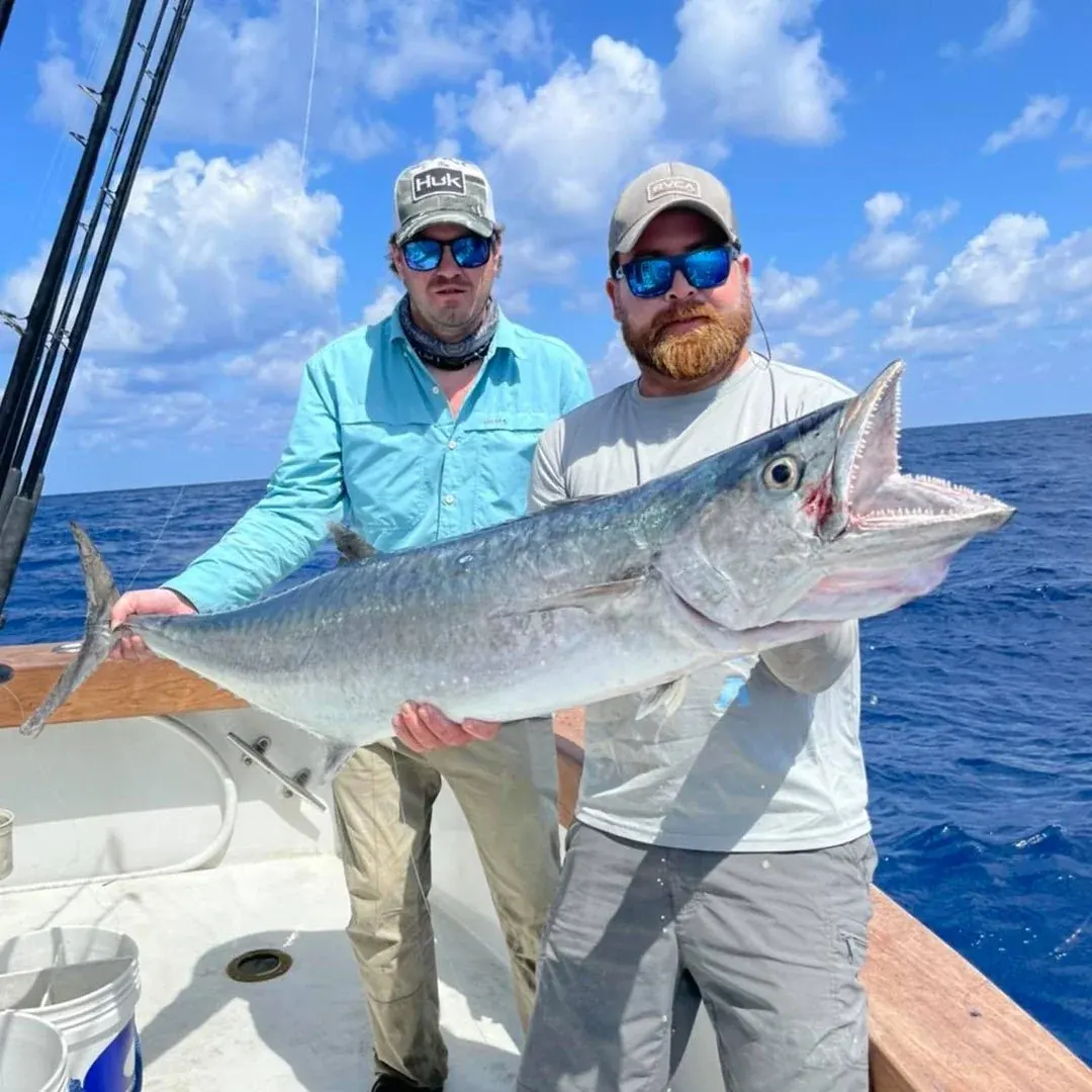Two anglers holding a smoker kingfish caught off Miami